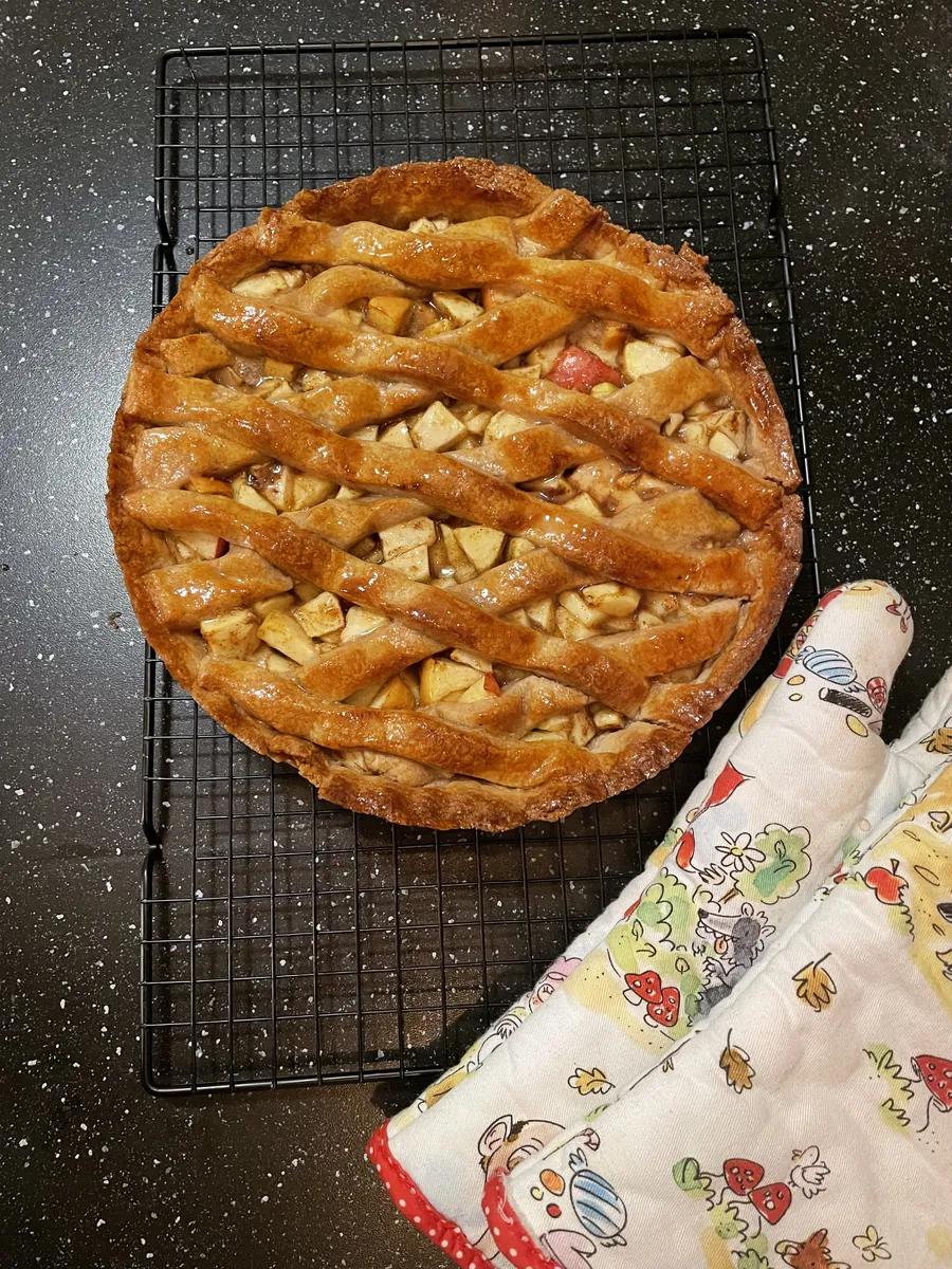 Appeltaart met een deegrooster op een afkoelrooster