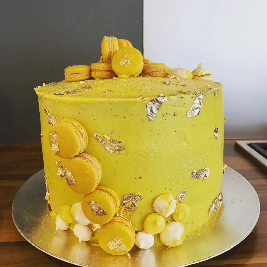 Gele taart met macarons en bladgoud